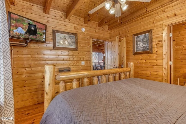 bedroom featuring beam ceiling, wooden walls, ceiling fan, and wooden ceiling