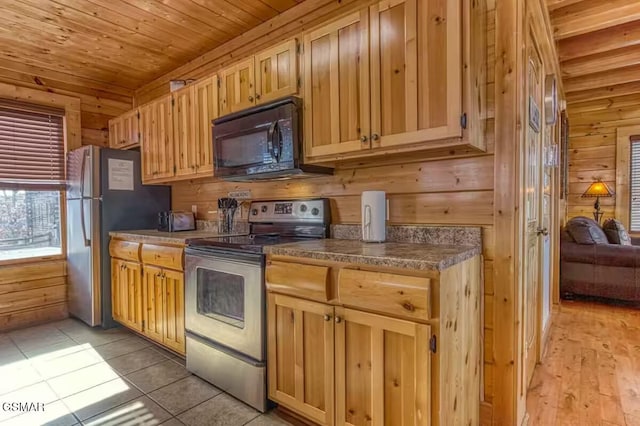 kitchen featuring wood ceiling, wooden walls, light tile patterned floors, and stainless steel appliances