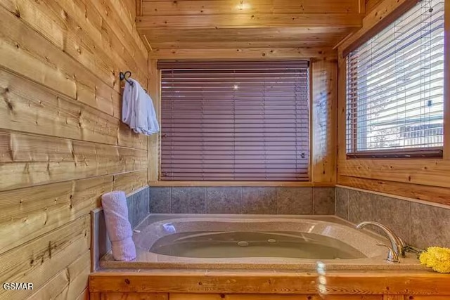 bathroom with a bathing tub, wooden walls, and wood ceiling