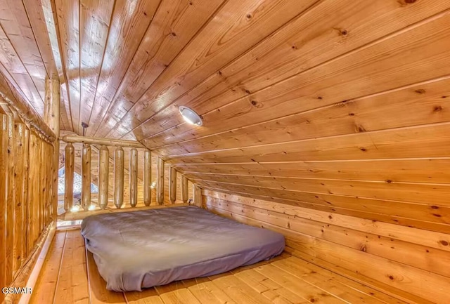 bedroom with wood walls, wooden ceiling, light hardwood / wood-style flooring, and vaulted ceiling