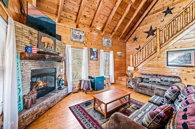 2251 Upper Middle Creek Rd Unit 8, Sevierville, TN 37876 - living area featuring wood-type flooring, wooden walls, a wooden ceiling with exposed beams, stairway, and a stone fireplace