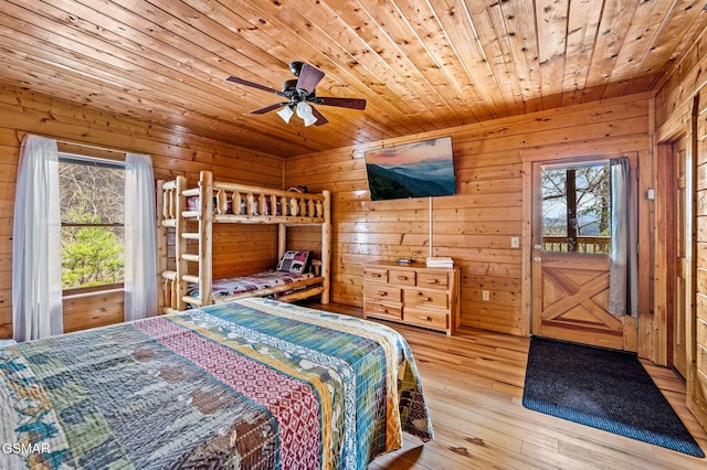 2251 Upper Middle Creek Rd Unit 8, Sevierville, TN 37876 - bedroom featuring wood ceiling, multiple windows, wooden walls, hardwood / wood-style floors, and access to exterior