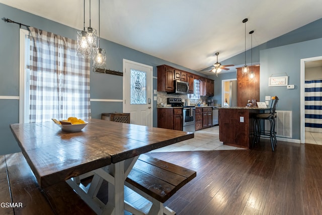 dining room with lofted ceiling, light hardwood / wood-style flooring, and ceiling fan