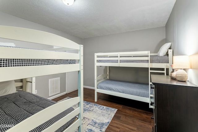 bedroom with dark wood-type flooring and a textured ceiling