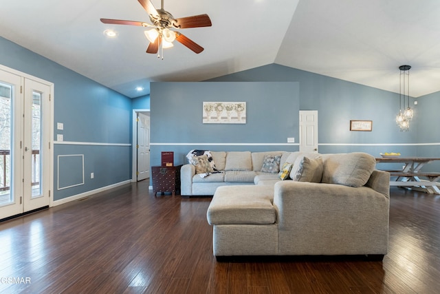 living room with lofted ceiling, ceiling fan with notable chandelier, and dark hardwood / wood-style floors