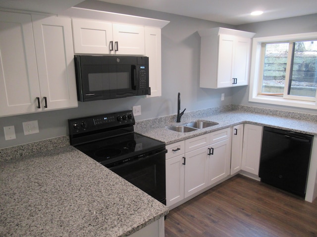 kitchen with dark wood-type flooring, black appliances, sink, light stone countertops, and white cabinetry