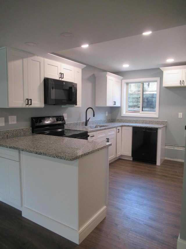 kitchen with white cabinetry, sink, kitchen peninsula, stone countertops, and black appliances