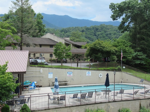 view of swimming pool featuring a mountain view and a patio