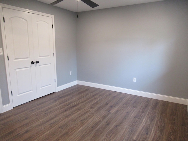 unfurnished bedroom with ceiling fan, dark hardwood / wood-style flooring, and a closet