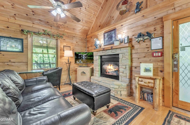 living area with wood-type flooring, ceiling fan, lofted ceiling, and wooden walls