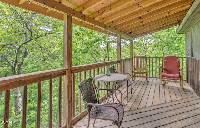 wooden terrace featuring a forest view