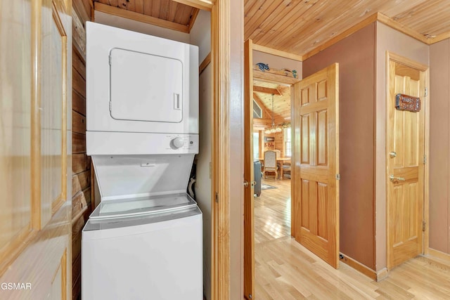 washroom with stacked washing maching and dryer, wood ceiling, baseboards, and light wood-style floors