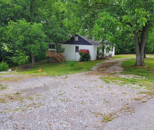 view of side of home with a wooden deck and a yard