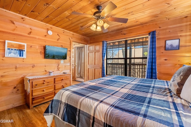 bedroom with wood walls, wood finished floors, wood ceiling, and access to exterior