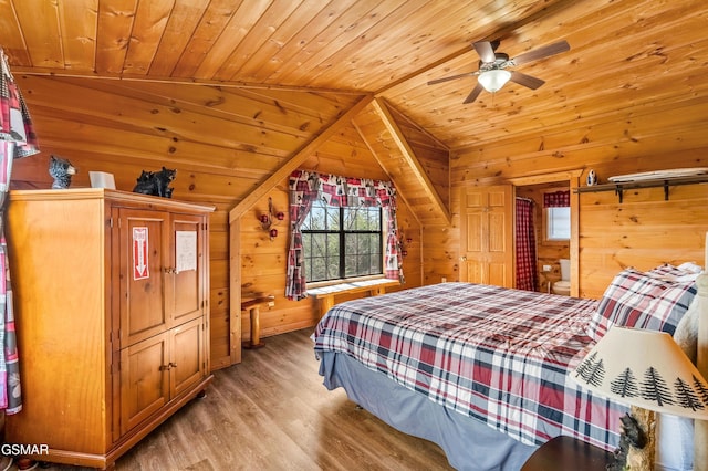 bedroom featuring vaulted ceiling, light wood-style floors, wood ceiling, and wooden walls