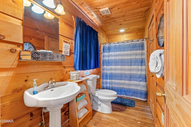 bathroom with visible vents, toilet, wood finished floors, a shower with curtain, and wooden ceiling