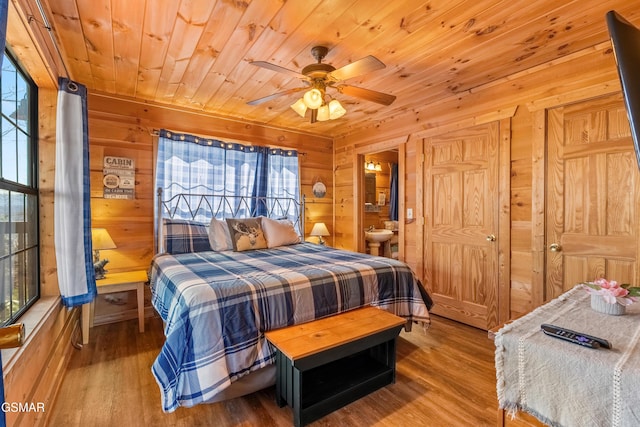 bedroom with wooden ceiling, multiple windows, wooden walls, and wood finished floors