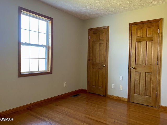 188 Riviera Dr, Newport, TN 37821 - unfurnished room with wood finished floors, baseboards, visible vents, and a healthy amount of sunlight
