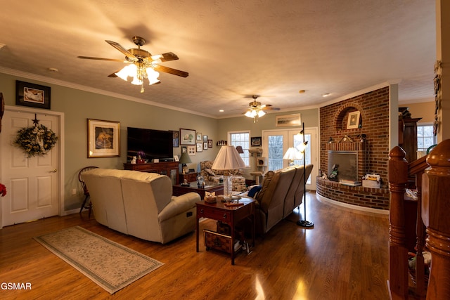 living room with hardwood / wood-style flooring, a healthy amount of sunlight, and a brick fireplace