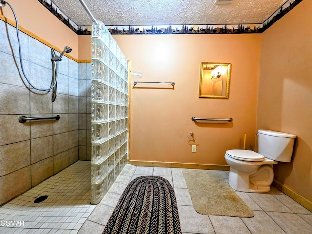 bathroom with toilet, a textured ceiling, a walk in shower, and tile patterned flooring