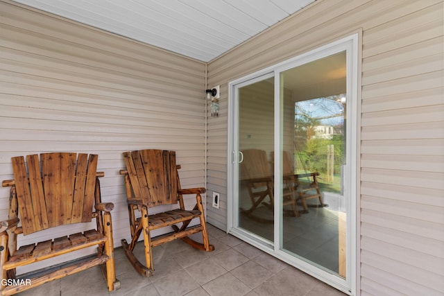 exterior space featuring wood walls and tile patterned floors