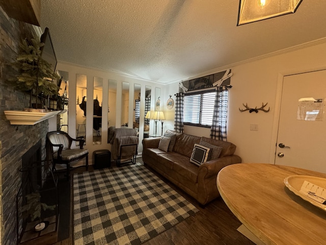 living room featuring dark wood-type flooring, a stone fireplace, and crown molding