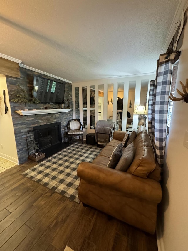 living room with a fireplace, hardwood / wood-style floors, a textured ceiling, and ornamental molding