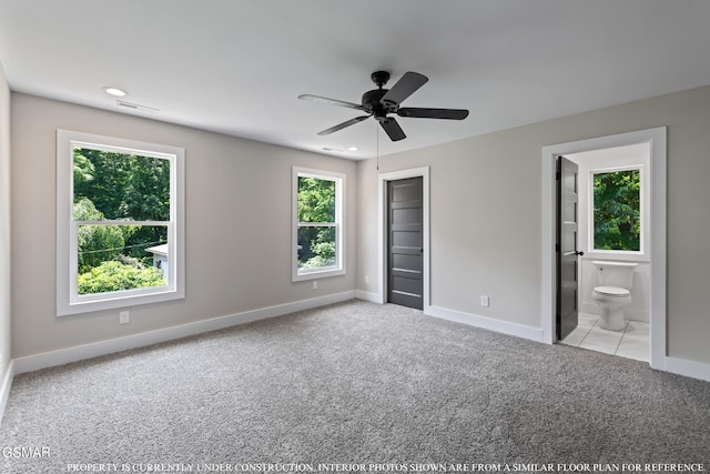 unfurnished bedroom with ensuite bath, ceiling fan, a closet, and light colored carpet