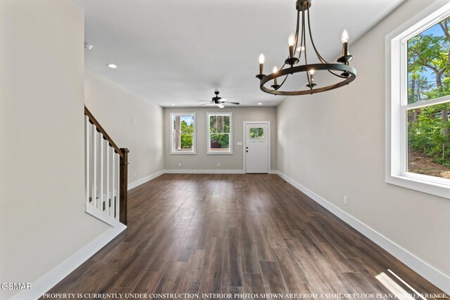 foyer entrance with ceiling fan with notable chandelier and dark hardwood / wood-style floors