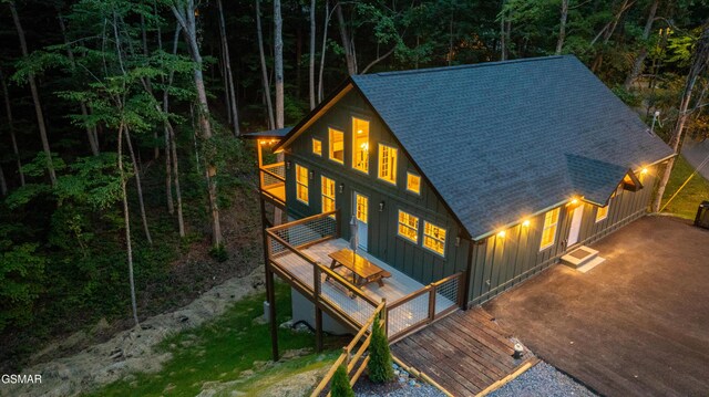 1504 Ginnys Trl, Sevierville, TN 37876 - rear view of property featuring board and batten siding, roof with shingles, a deck, and a wooded view