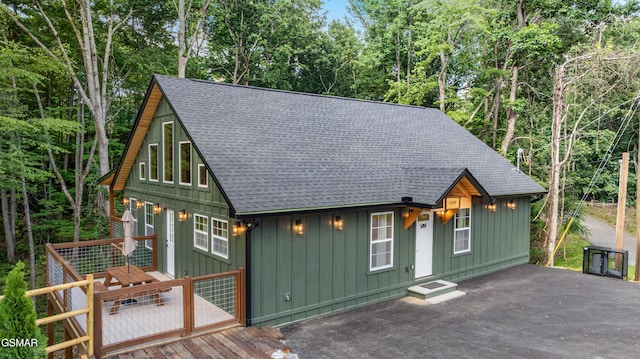 1504 Ginnys Trl, Sevierville, TN 37876 - chalet / cabin featuring a shingled roof, board and batten siding, a deck, and view of wooded area