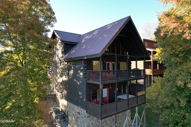 rear view of house featuring metal roof and a balcony