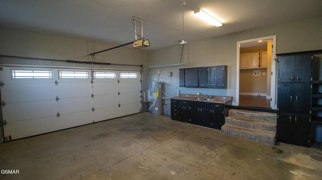 garage with sink, a garage door opener, and water heater