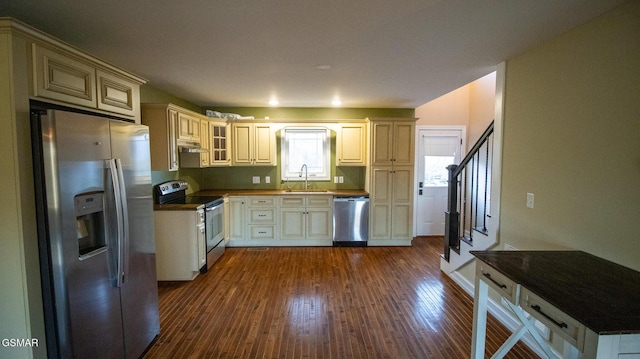 kitchen with cream cabinets, sink, dark wood-type flooring, and appliances with stainless steel finishes