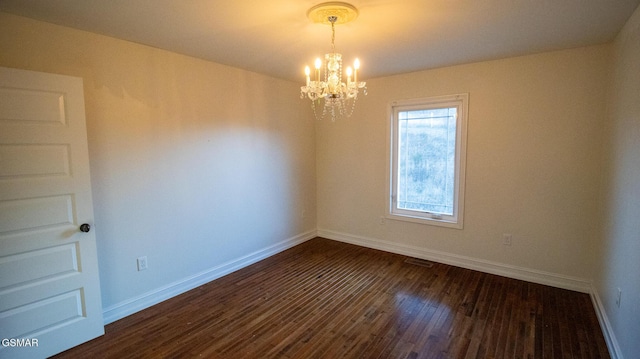 unfurnished room with dark wood-type flooring and a chandelier