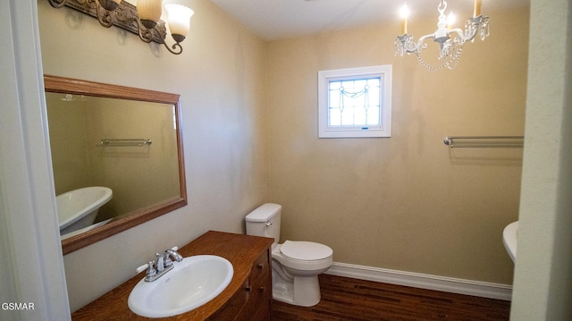 bathroom featuring a chandelier, hardwood / wood-style floors, toilet, and sink