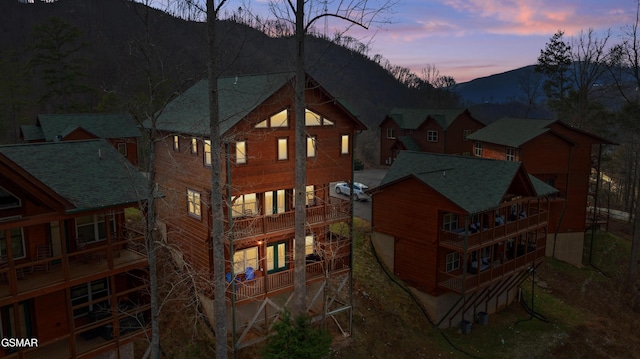 back house at dusk with a balcony and a mountain view