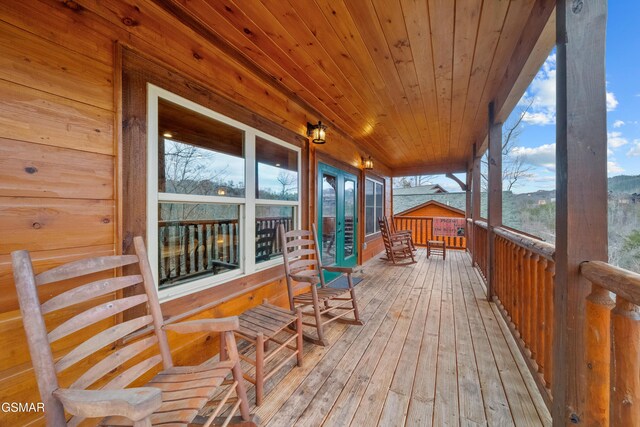 sunroom / solarium featuring a mountain view and wood ceiling