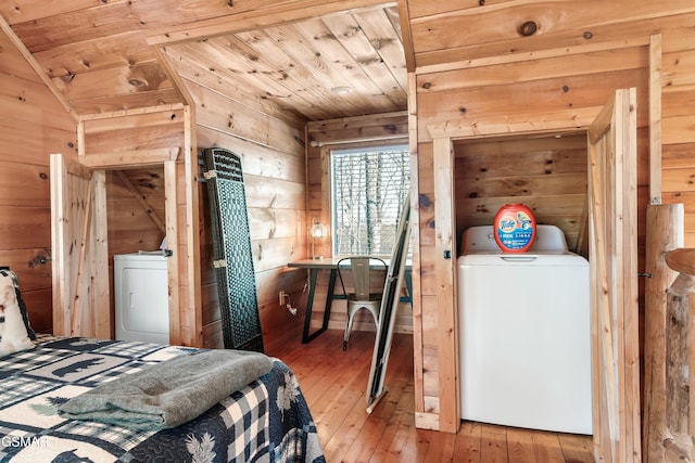 bedroom featuring wooden walls, washer / clothes dryer, hardwood / wood-style floors, and wood ceiling