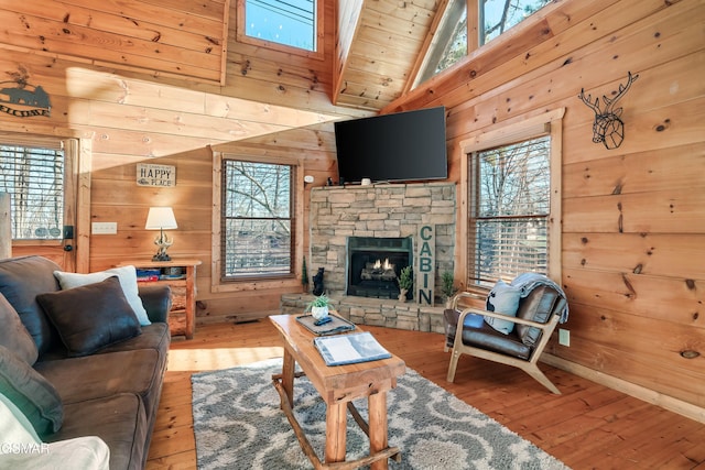 living room with hardwood / wood-style flooring, wooden walls, high vaulted ceiling, a fireplace, and wooden ceiling