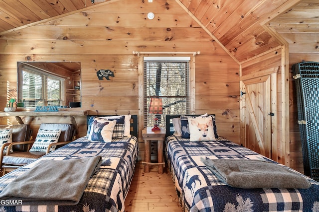 bedroom featuring wood ceiling, light hardwood / wood-style flooring, wooden walls, and vaulted ceiling