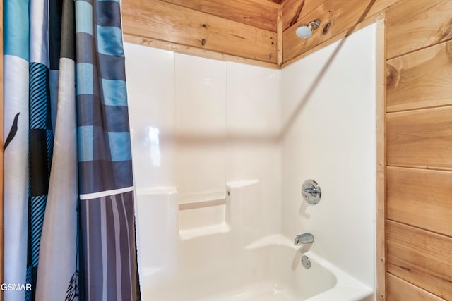 bathroom featuring shower / bath combo and wood walls