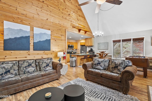 334 Greenwood Way, Pigeon Forge, TN 37863 - living room with light wood-style floors, a chandelier, high vaulted ceiling, wooden walls, and a mountain view