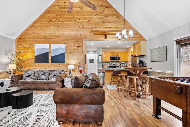 334 Greenwood Way, Pigeon Forge, TN 37863 - living room featuring high vaulted ceiling, wooden walls, light wood finished floors, a chandelier, and a ceiling fan
