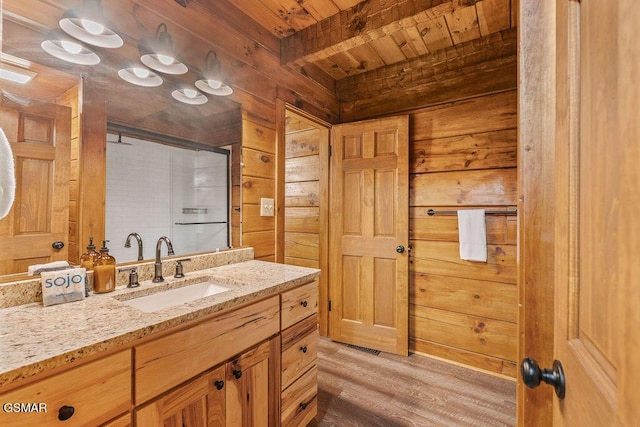 4372 Boogertown Rd Unit 1, Sevierville, TN 37876 - bathroom featuring wood ceiling with exposed beams, wood walls, vanity, wood finished floors, and a shower with door