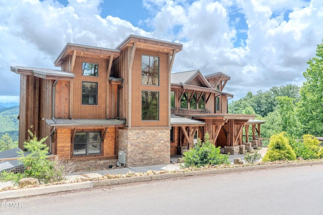 2414 Hackberry Dr, Sevierville, TN 37862 - contemporary house with stone siding, a metal roof, and board and batten siding
