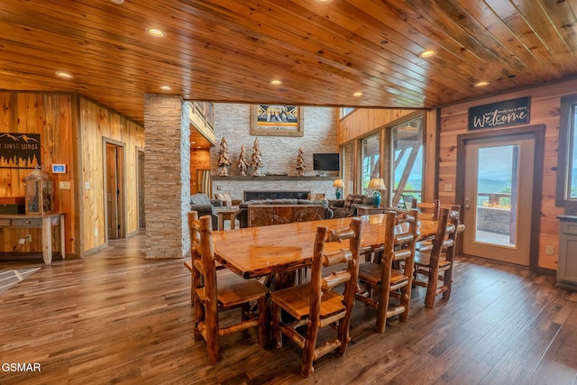 2414 Hackberry Dr, Sevierville, TN 37862 - dining area featuring wood ceiling, a stone fireplace, wooden walls, and wood finished floors