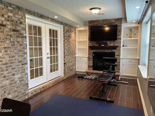1018 Southwind Cir, Dandridge, TN 37725 - living area featuring a textured ceiling, french doors, a stone fireplace, wood tiled floors, and recessed lighting