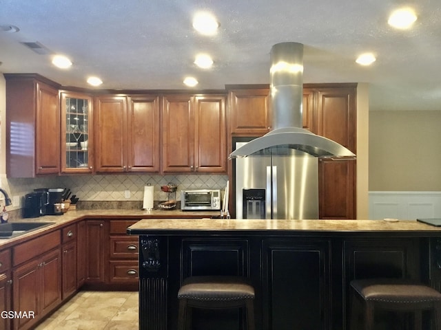 1018 Southwind Cir, Dandridge, TN 37725 - kitchen featuring island exhaust hood, stainless steel fridge, glass insert cabinets, decorative backsplash, and recessed lighting
