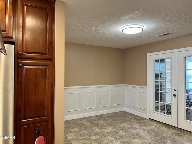 1018 Southwind Cir, Dandridge, TN 37725 - spare room with french doors, a textured ceiling, and a wainscoted wall